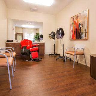 A cozy waiting area in a hair salon featuring comfortable seating and vibrant artwork.