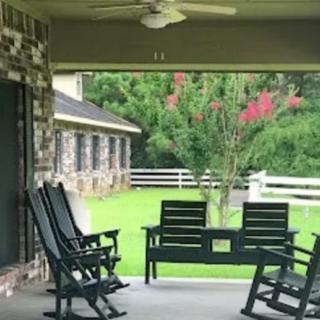 A cozy porch with rocking chairs overlooking a lush green lawn.