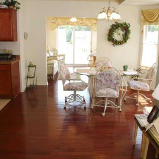 A cozy dining area with floral seating and hardwood floors.