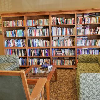 A cozy library corner with bookshelves and comfortable seating.