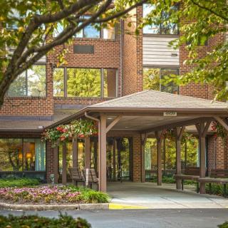 A building entrance with a canopy and surrounding greenery.