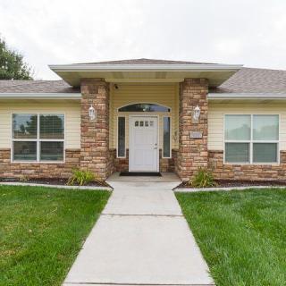 A modern single-story house with a brick facade and well-maintained lawn.