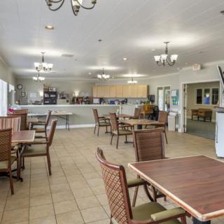 A well-lit dining area with tables and chairs arranged neatly.