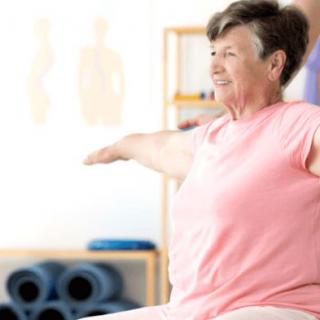 A senior woman practicing yoga indoors, focusing on well-being and fitness.