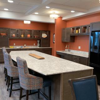 A modern kitchen with a large island, bar stools, and sleek cabinetry.