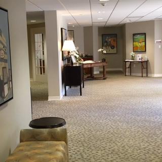 A spacious lobby area featuring comfortable seating, decorative artwork, and a well-lit environment.