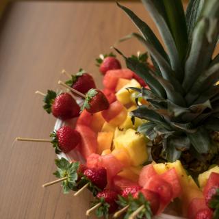 A colorful arrangement of fruits including strawberries and pineapple on skewers.