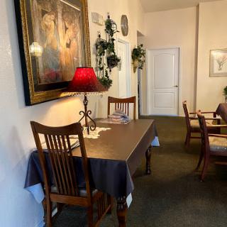A cozy dining area featuring a wooden table with a lamp and tasteful wall decor.