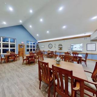 A spacious dining area with wooden furniture and modern lighting.