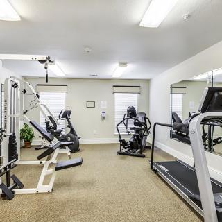 A fitness room with various exercise machines and equipment.