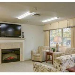 Cozy living room with a television above the fireplace, surrounded by comfortable seating.