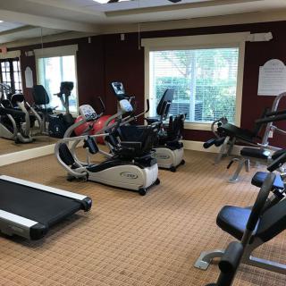 A well-equipped gym with various fitness machines including treadmills and exercise bikes.
