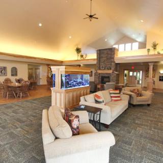 A spacious and modern living room featuring comfortable sofas, a large fish tank, and an adjacent dining area.