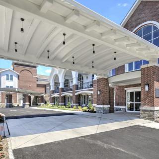 A modern brick building with a covered entrance and driveway.