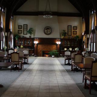 A spacious and elegantly designed lobby featuring comfortable seating, bookshelves, and a cozy fireplace.