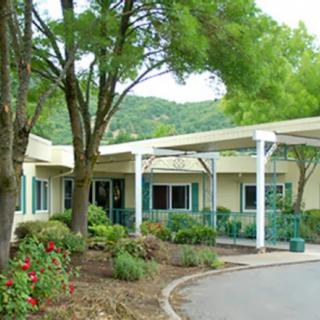 A scenic view of a building entrance surrounded by trees and greenery.