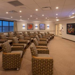 A well-lit waiting room with rows of comfortable chairs and artwork adorning the walls.