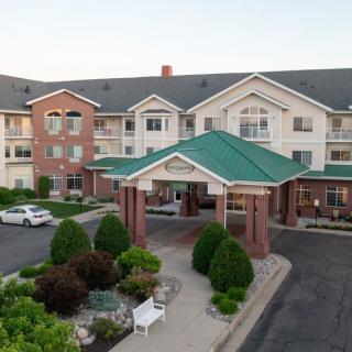 A hotel building with a covered entrance and neatly landscaped surroundings.