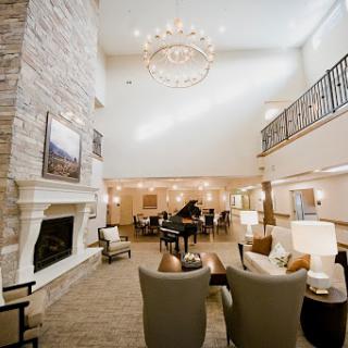 A spacious and elegantly designed living room with a chandelier, fireplace, and comfortable seating.