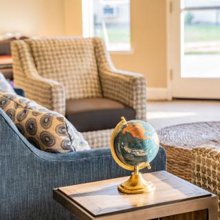 A cozy living room setting with a globe on a side table and comfortable armchairs.
