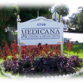 Sign for Medicana Nursing and Rehab Center surrounded by plants.