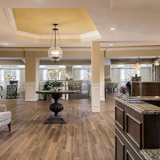 A spacious and elegantly designed lobby with modern furniture and wood flooring.