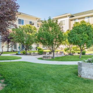 A well-maintained apartment complex with lush green lawns and trees.