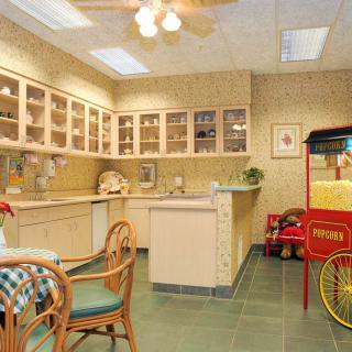 A cozy kitchen interior with a seating area and a vintage popcorn machine.