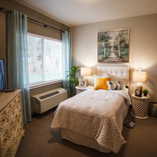 A cozy bedroom with a single bed, soft lighting, and tasteful decor.