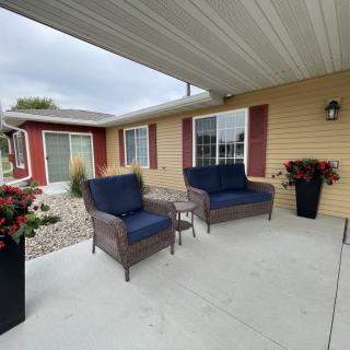 A cozy outdoor patio with wicker seating and potted plants.