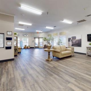 A spacious and modern lobby with comfortable seating, featuring wood flooring and bright lighting.