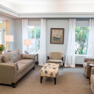 A cozy living room with neutral colors featuring a sofa, armchairs, and a coffee table.