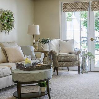 A cozy living room with a sofa, armchair, and coffee table, featuring elegant decor and natural lighting.