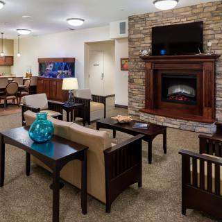 A cozy living room with a stone fireplace and comfortable seating.