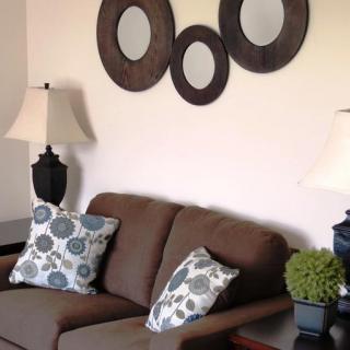 A cozy living room with a brown sofa, decorative cushions, and modern wall art.