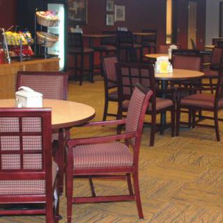 An empty cafeteria with neatly arranged tables and chairs.