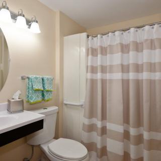 A well-lit bathroom with a shower curtain and modern amenities.
