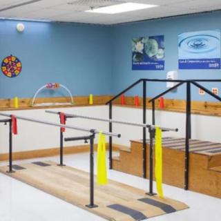 A physical therapy room equipped with parallel bars for rehabilitation exercises.