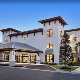 A modern residential building with a welcoming entrance, captured in the evening light.