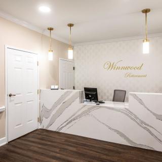 A modern reception area with a marble-patterned desk and stylish lighting.