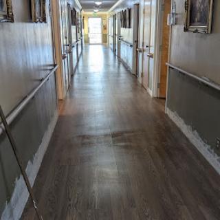 A well-lit hallway featuring smooth flooring and doors on either side.