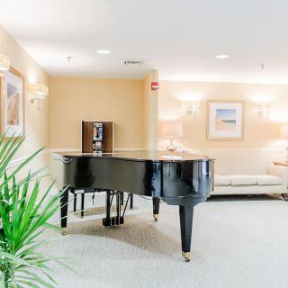 A cozy living room featuring a grand piano with modern decor.