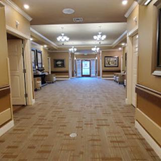 A well-lit hallway featuring decorative frames on the walls, leading to a doorway.