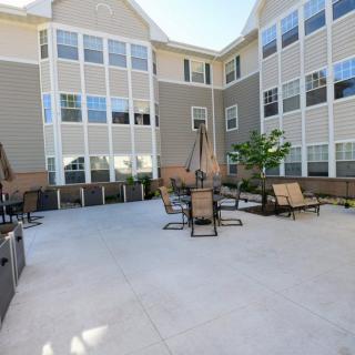 An outdoor courtyard with seating furniture surrounded by residential buildings on a sunny day.