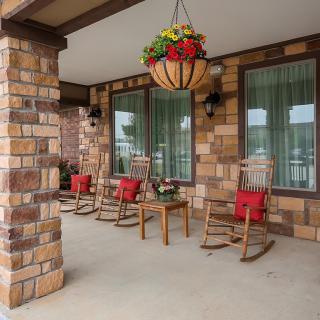 A cozy porch with rocking chairs and a hanging plant.