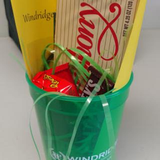 A colorful green container filled with snacks and popcorn, perfect for sharing at a celebration.