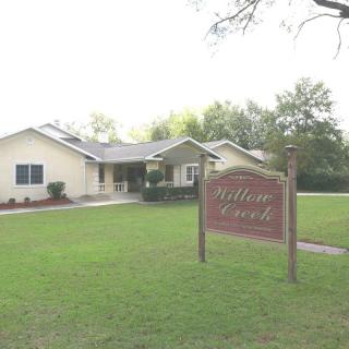 A house with a well-maintained lawn and a sign in the front yard.