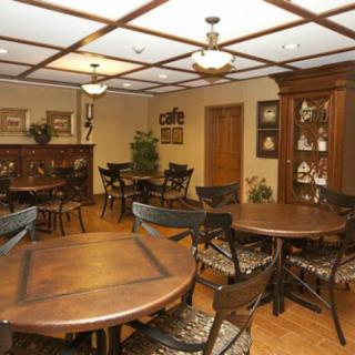 A cozy dining room with wooden furniture and round tables.