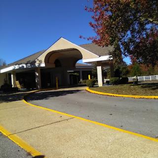 A view of a building entrance with a clear blue sky and fall foliage.
