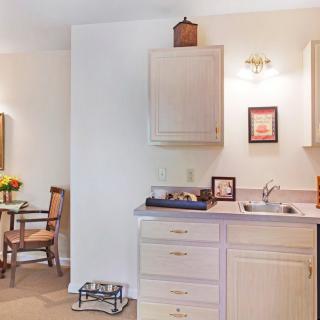 A cozy kitchen interior with a dining area and cabinets.